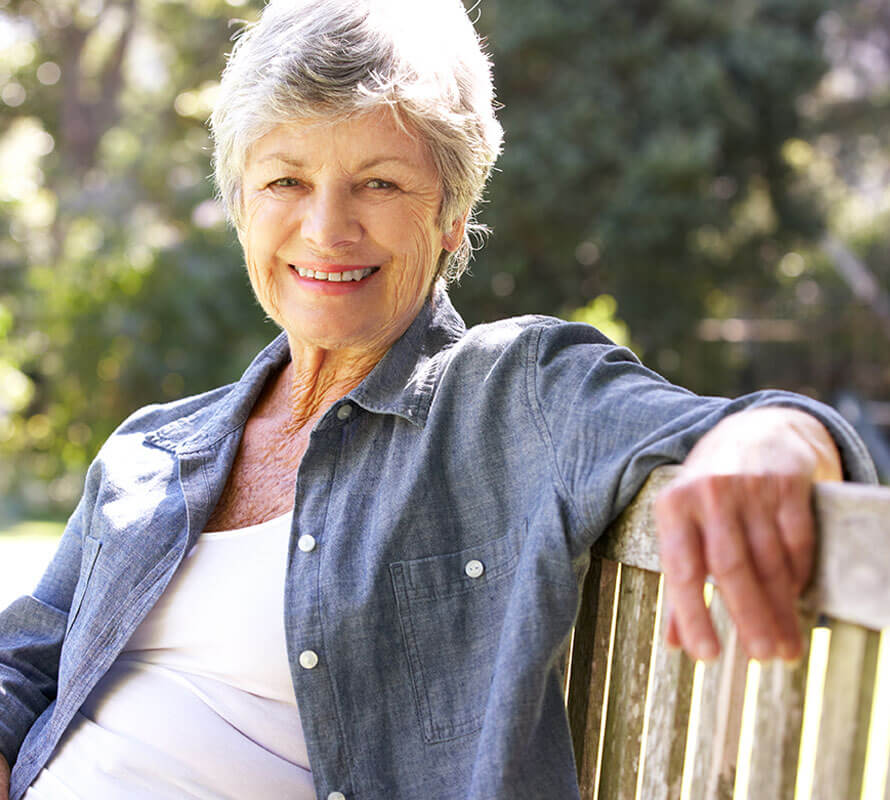 Older Woman Sitting on a Bench Smiling